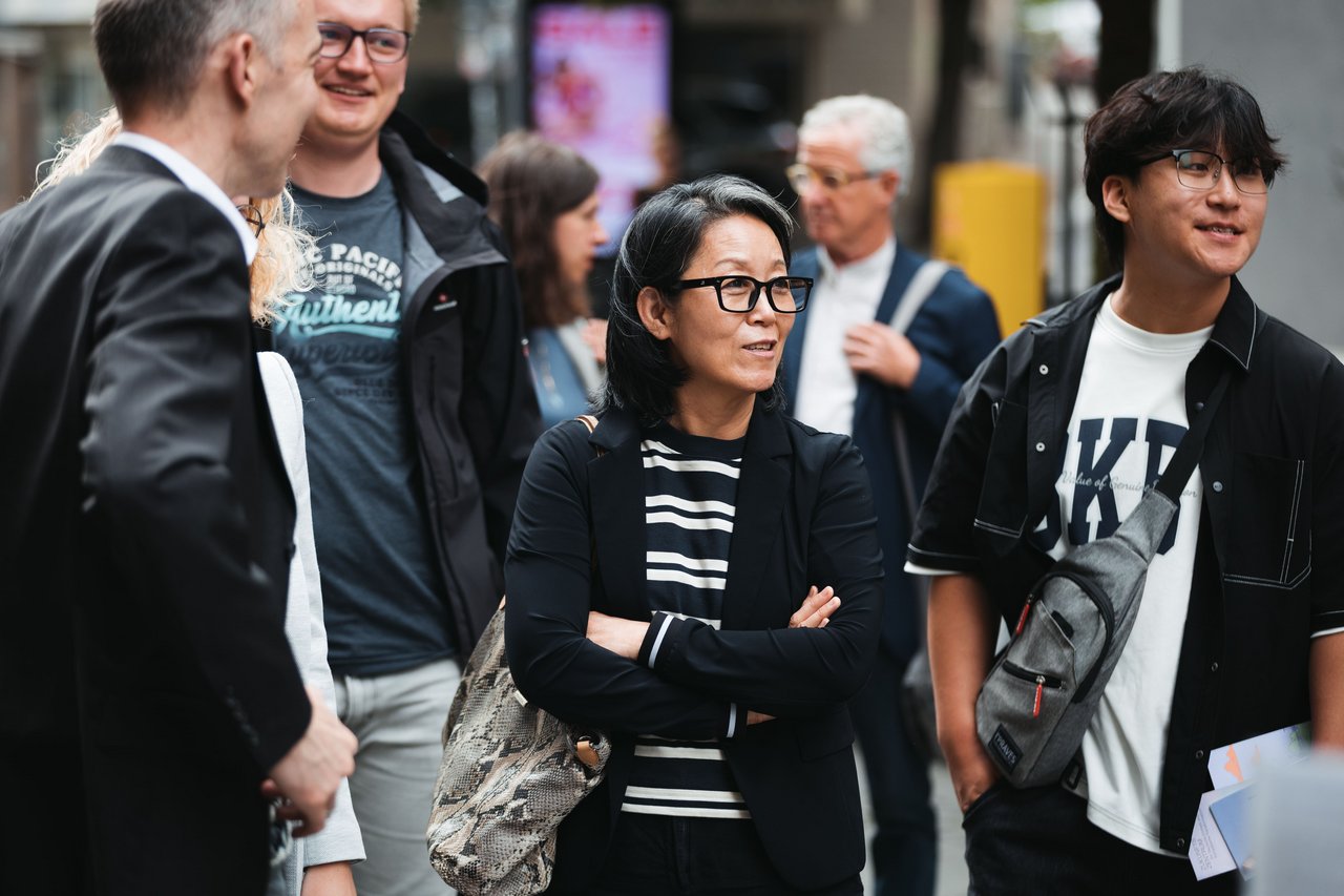 Koreanische Gäste der Podiumsdiskussion stehen vor Café Koffij