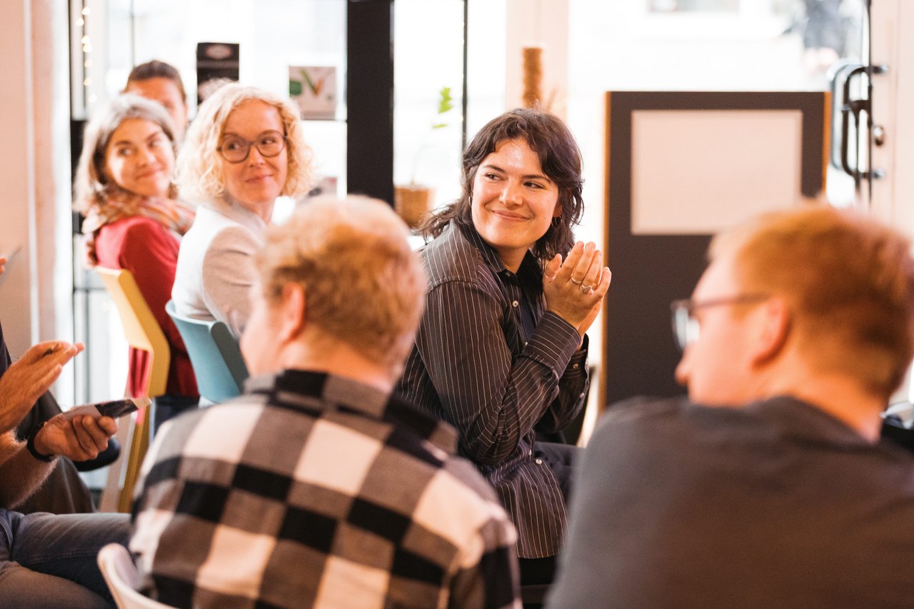 Gäste in der ersten Reihe drehen sich nach hinten um eine Publikumsfrage besser zu verstehen